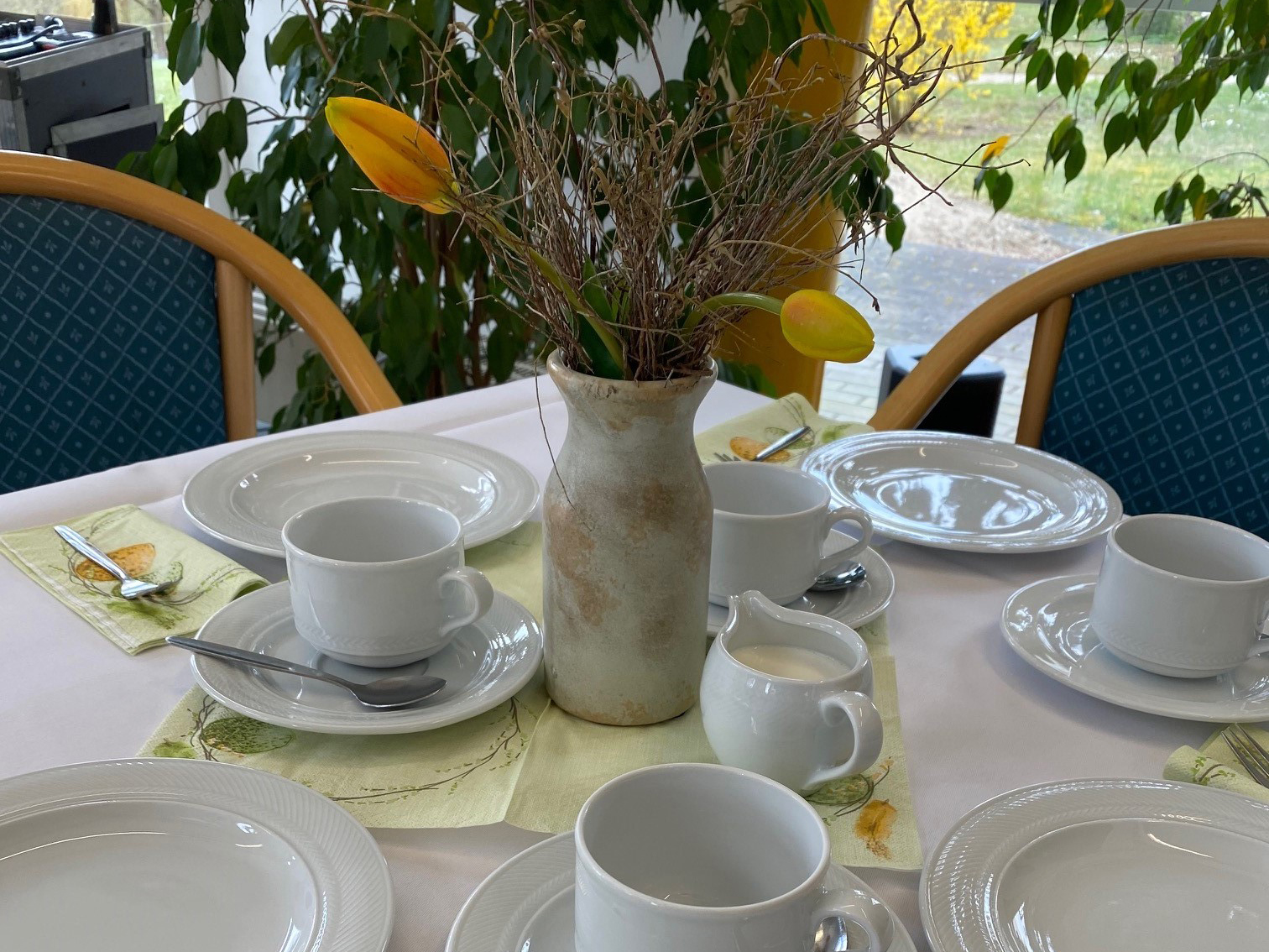 Gedeckter Kaffeetisch mit Blumenstrauß