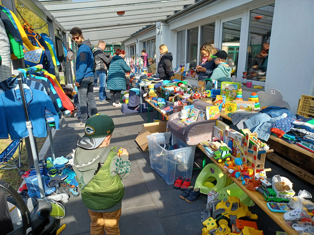 Flohmarkt mit Kinderspielzeug und Kleidungstischen