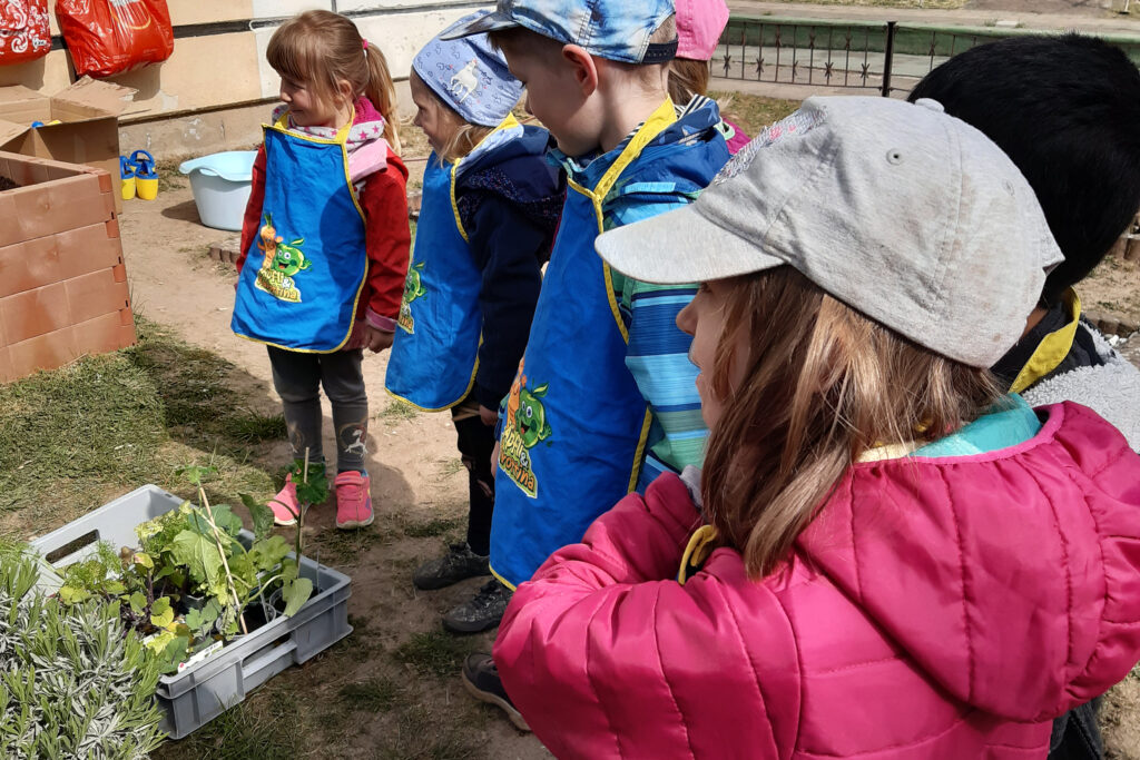 Kinder, die draußen in einem Gartenbereich stehen