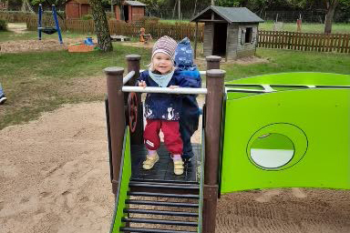Zwei Kleinkinder spielen auf einem Spielplatz.