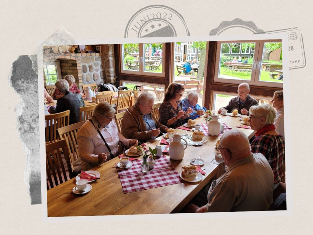 Eine Gruppe älterer Menschen sitzt an einem Tisch und genießt Kaffee und Kuchen.