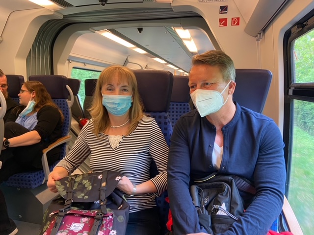 Zwei Personen mit Gesichtsmasken sitzen in einem Zug.