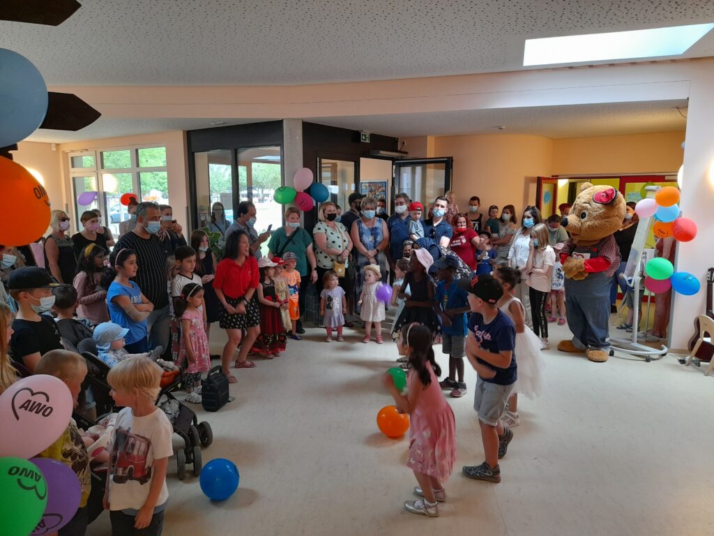 Eine Gruppe von Menschen feiert zusammen in einem hellen Raum.