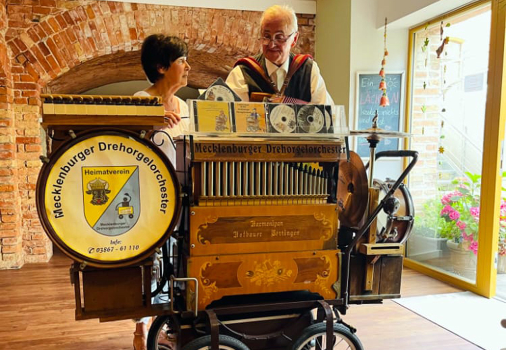 Zwei Personen neben einer Drehorgel
