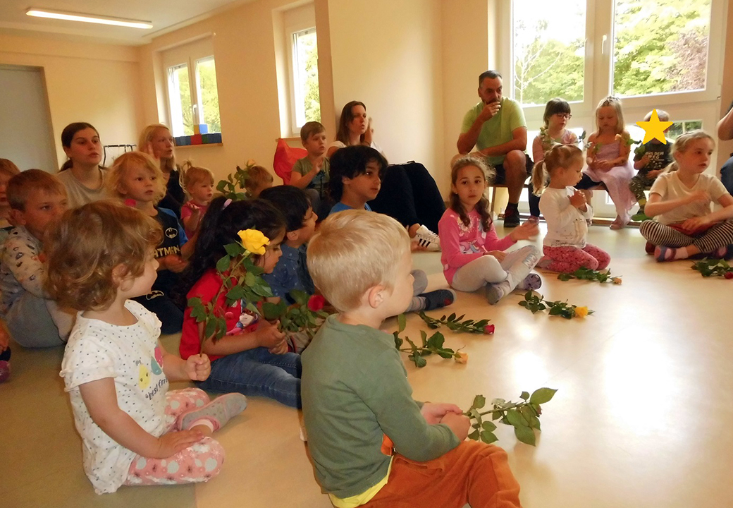 Kinder mit Blumen sitzen in einem Raum