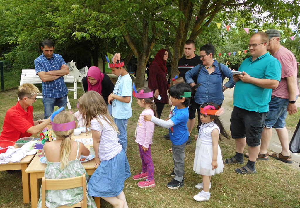 Mehrere Kinder und Erwachsene bei einem Freiluft-Event