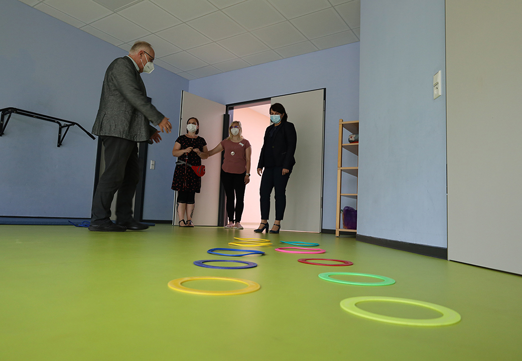 Personen in einem Raum mit farbigen Reifen auf dem Boden.