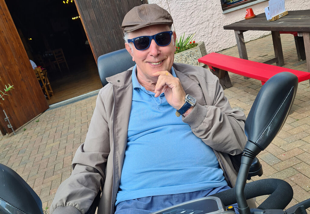 &Auml;ltere m&auml;nnliche Person auf einem Mobilit&auml;tsscooter