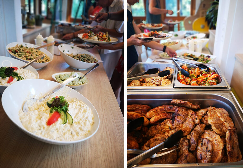 Buffet mit verschiedenen Speisen, Menschen servieren sich Essen.