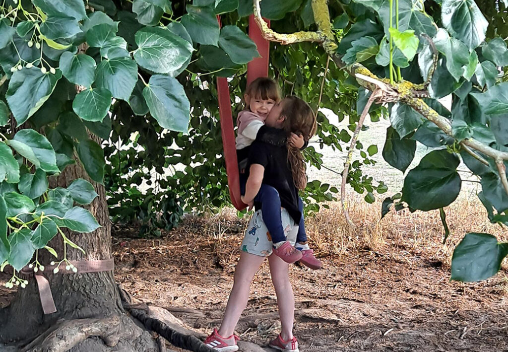 Zwei Kinder spielen unter einem Baum