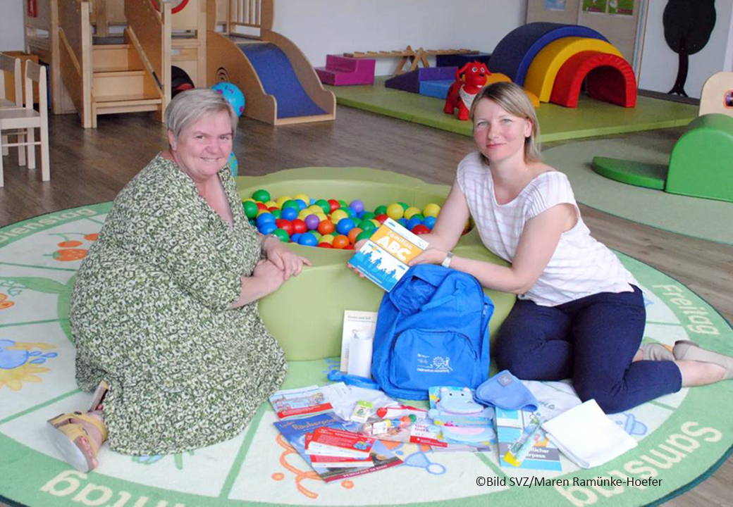 Zwei Frauen in einer Kindertagesstätte vor einem Bällebad