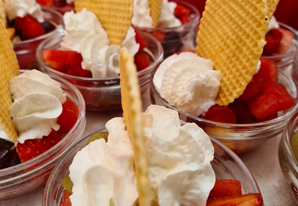 Desserts in kleinen Gl&auml;sern mit Sahne, Obst und Waffeln