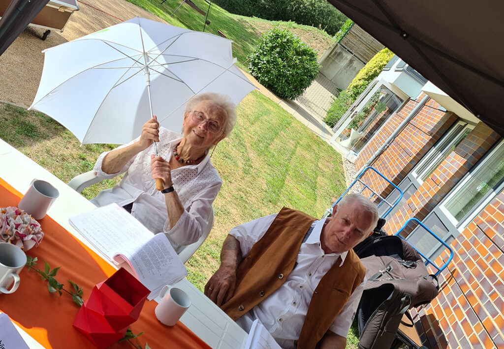 &Auml;lteres Paar sitzt drau&szlig;en an einem Tisch