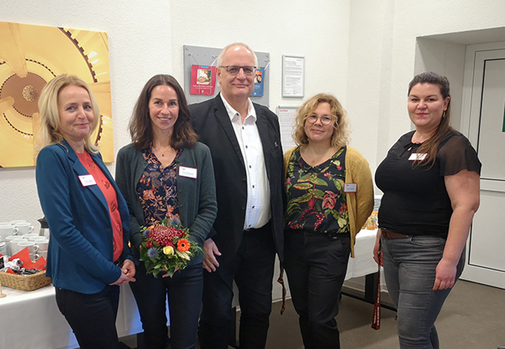 Gruppe von fünf Personen in einem Raum mit einem Tisch Hintergrund