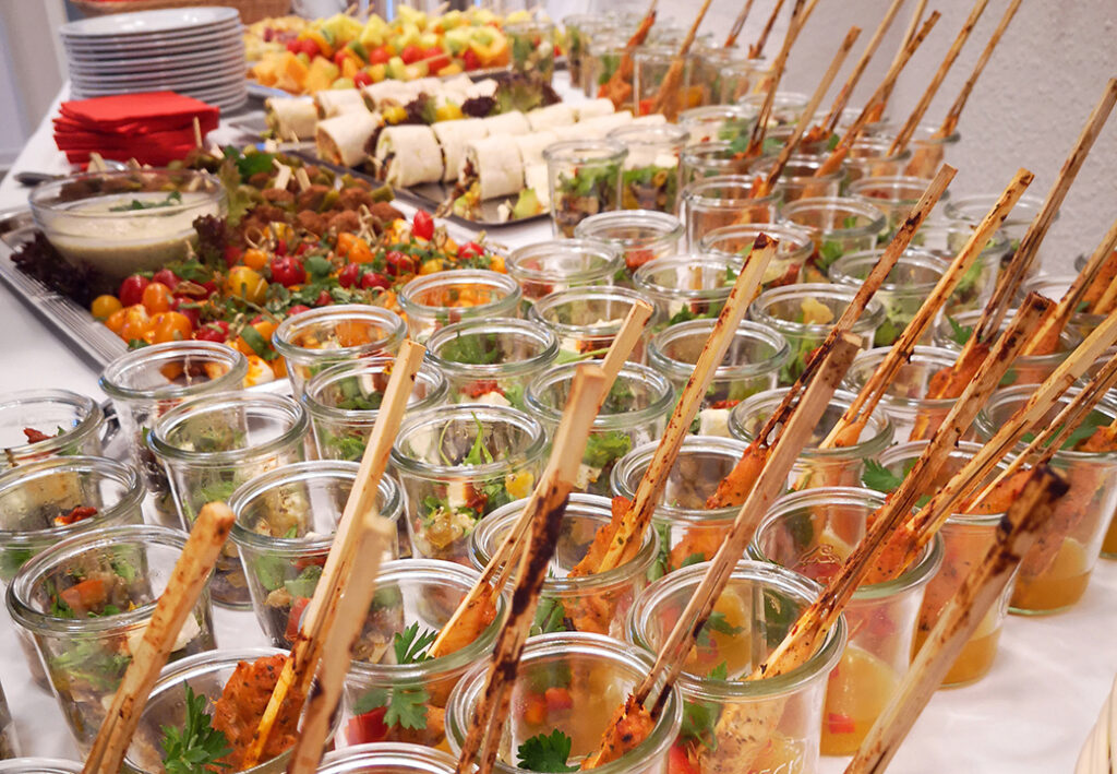 Ein Buffet mit verschiedenen Speisen in Gl&auml;sern und auf Platten.
