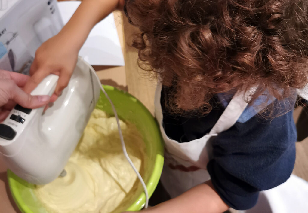 Kind hilft beim Kuchenr&uuml;hren