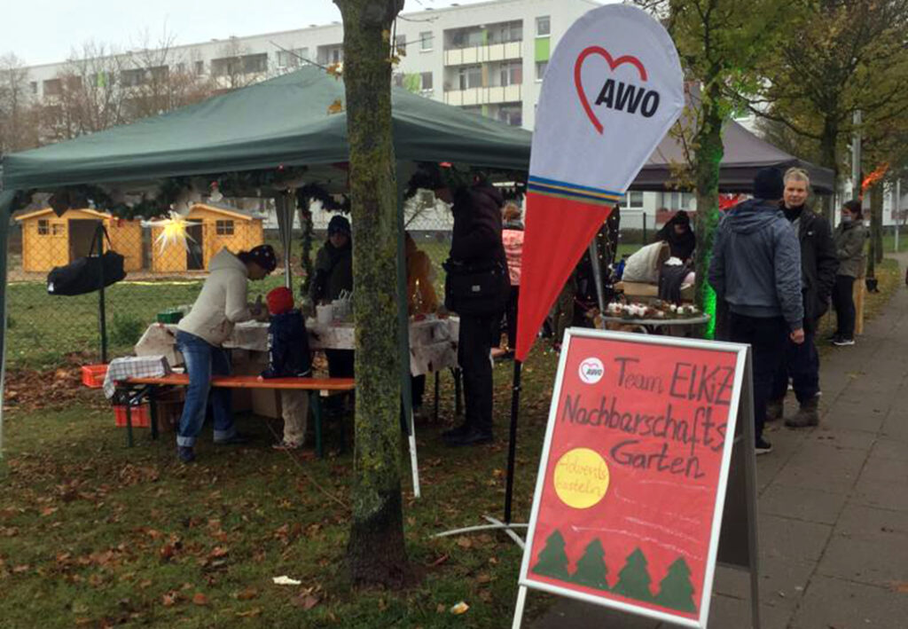 Eine Szene von einem Marktzelt mit AWO-Banner und Infotafel