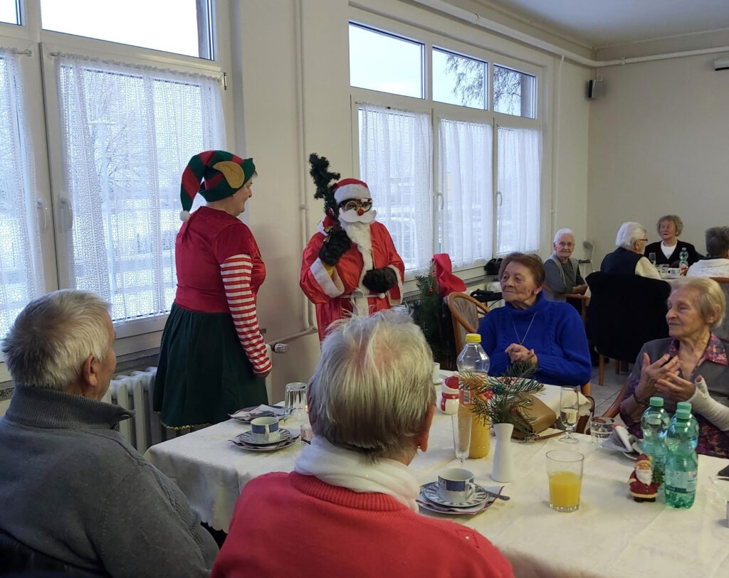 Seniorengruppe feiert mit weihnachtlich verkleideten Personen
