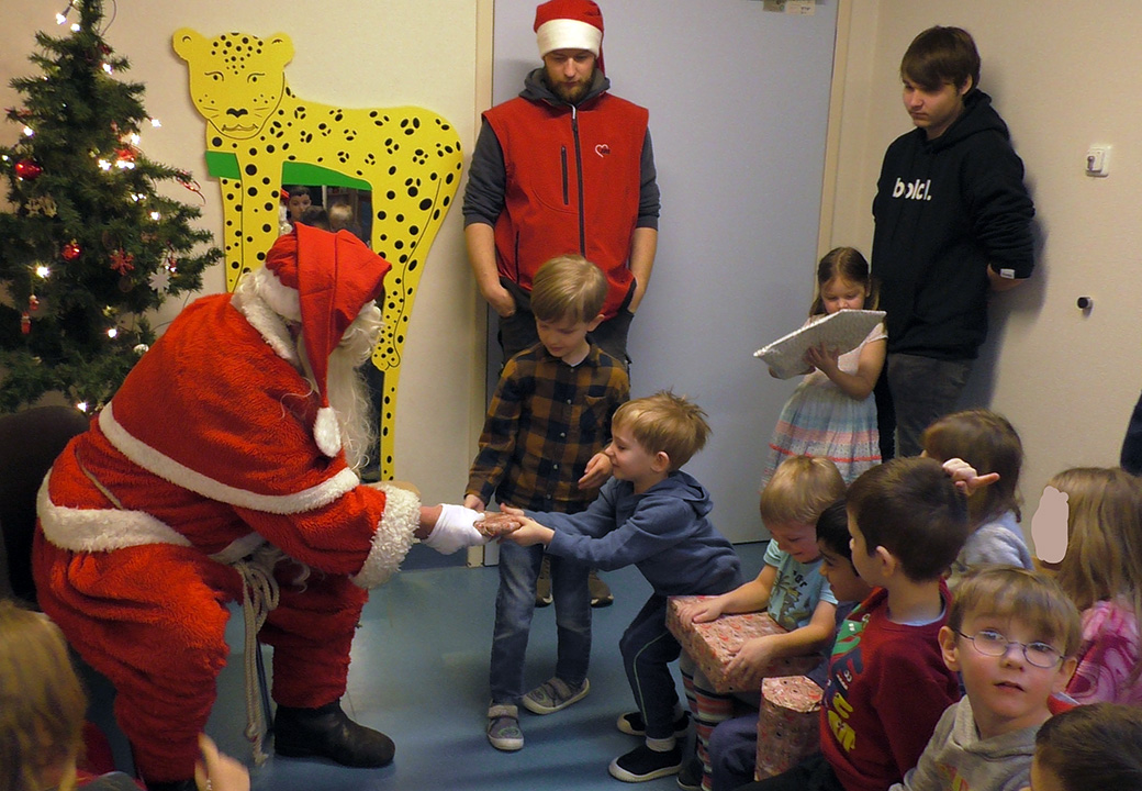Weihnachtsmann verteilt Geschenke an Kinder
