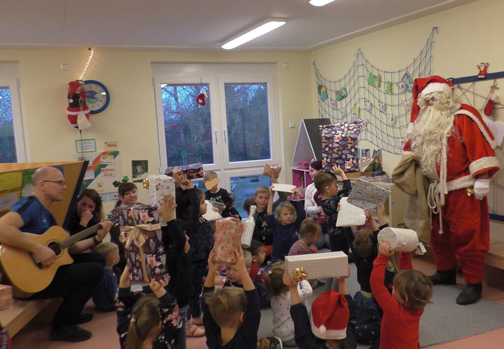 Kinder feiern mit dem Weihnachtsmann in einem Raum