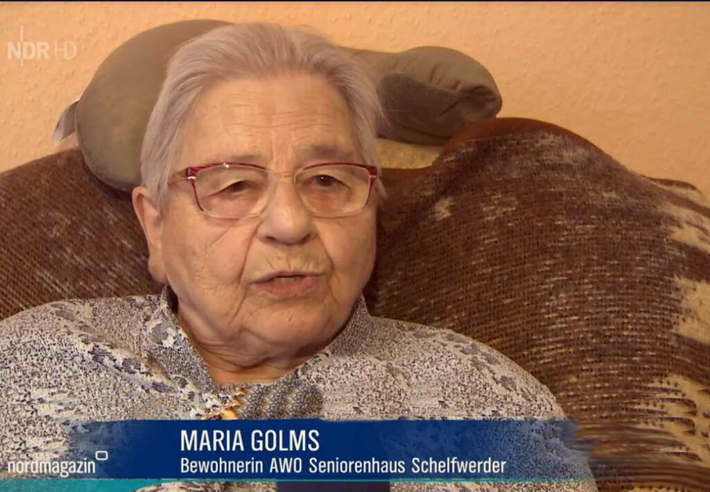 Eine &auml;ltere Frau auf einem Sofa sitzend