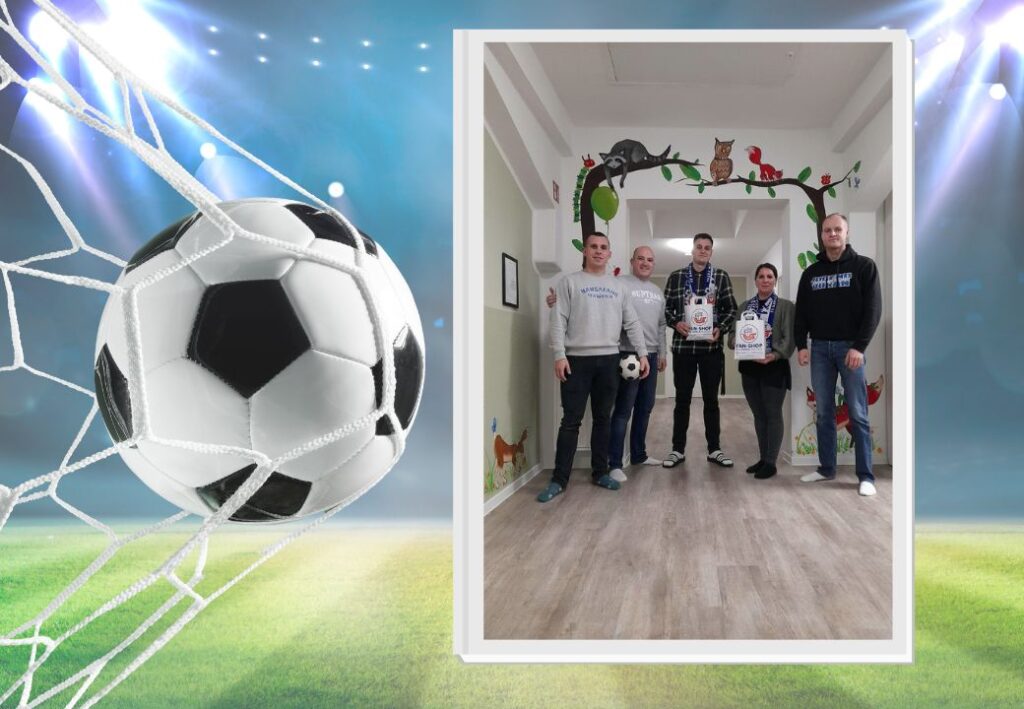 Gruppe von fünf Personen in einem Flur mit Fußballmotiv im Hintergrund