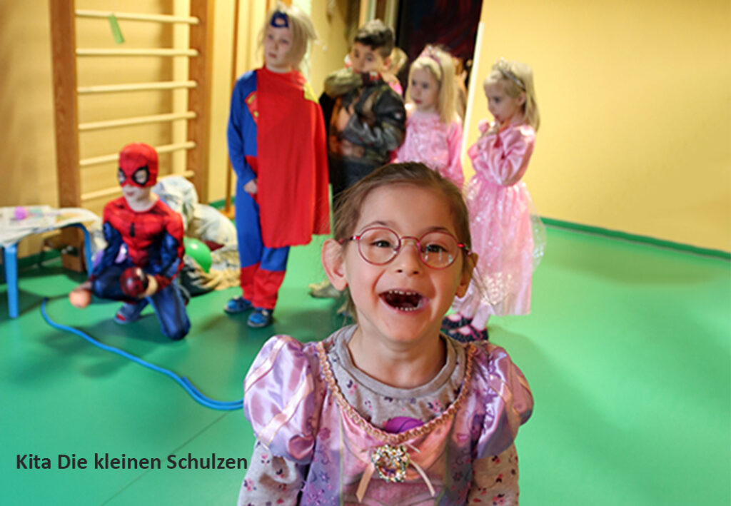 Kinder in Kost&uuml;men in einem Raum mit gr&uuml;nem Boden