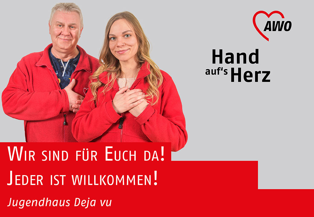 Zwei Personen in roten Jacken mit Hand aufs Herz-Geste vor einem AWO-Logo.