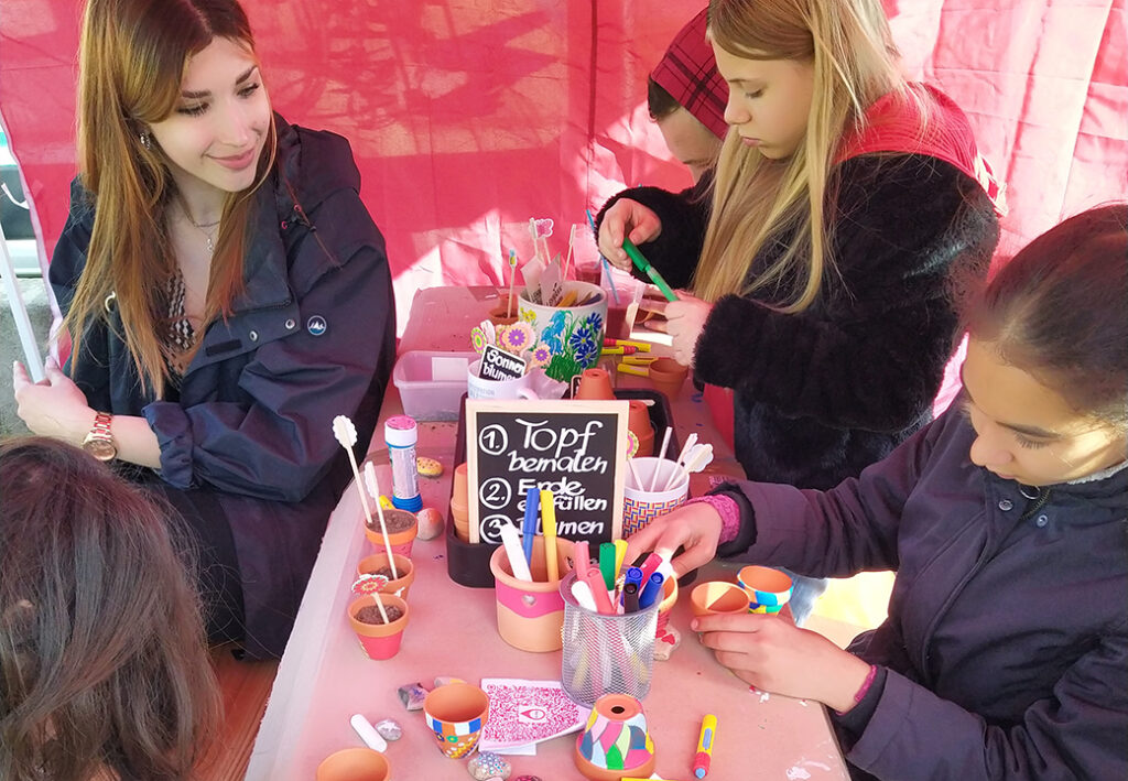 Ein Bild von mehreren Personen, die an einem Tisch basteln.