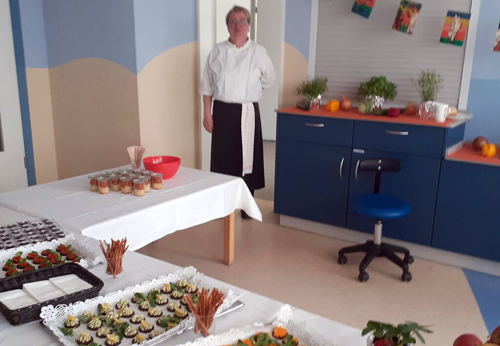 Person in wei&szlig;em Hemd in K&uuml;che neben gedecktem Tisch