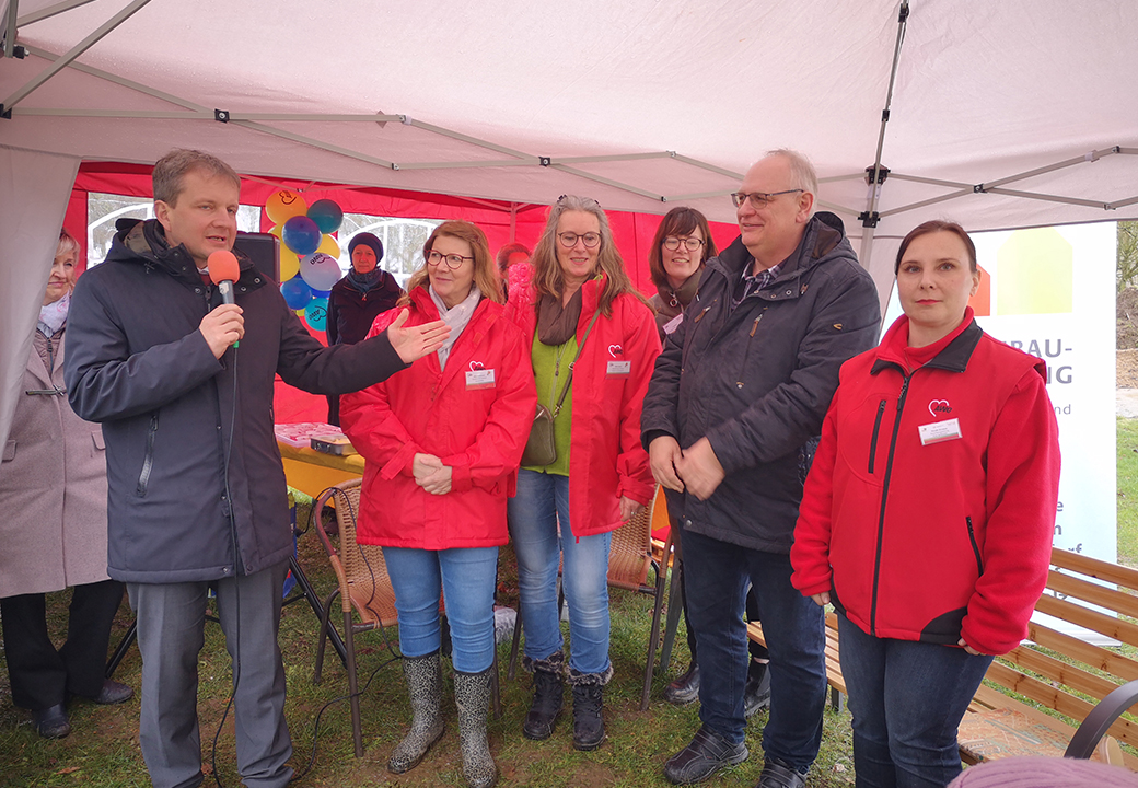 Eine Gruppe von Personen steht unter einem weißen Pavillon.