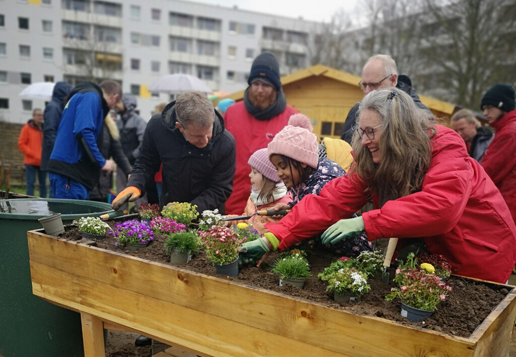 Menschen beim Pflanzen in einem Gemeinschaftsgarten.