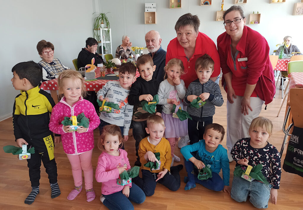 Eine Gruppe von Kindern und Erwachsenen versammelt sich in einem Raum.