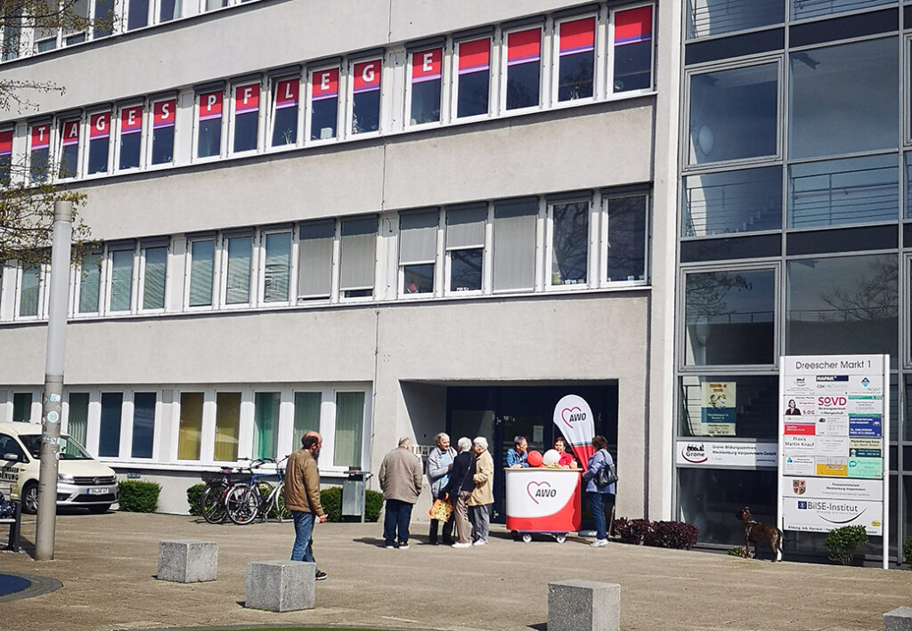 AWO-Geb&auml;ude mit Personen und Informationsstand