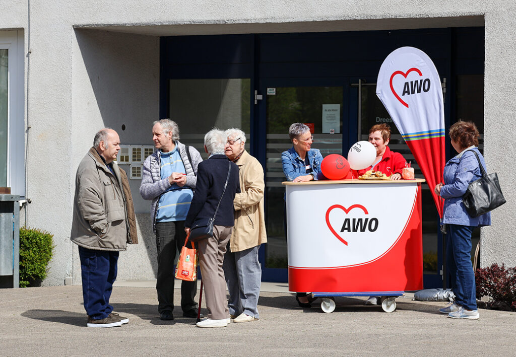 Menschen versammeln sich vor einem AWO-Infostand.