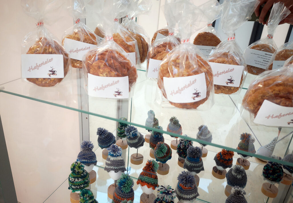 Verpackte Haferkekse und gestrickte Mützen in Vitrine