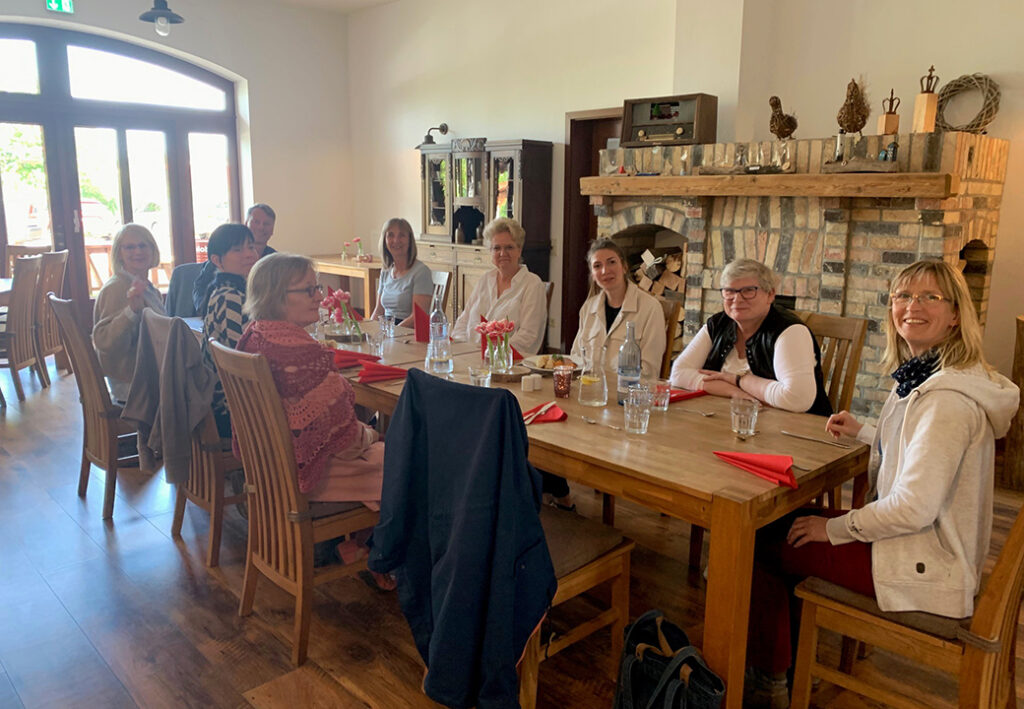 Menschen, die an einem Tisch in einem Raum mit Kamin sitzen