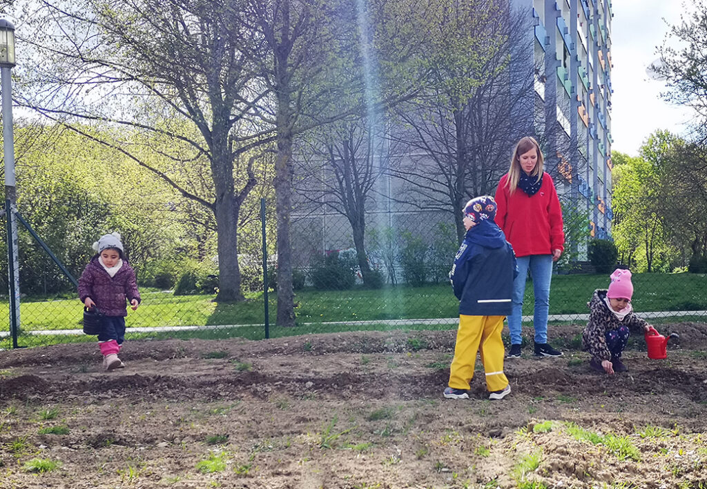 Kinder beim Spielen im Freien mit einer Betreuerin