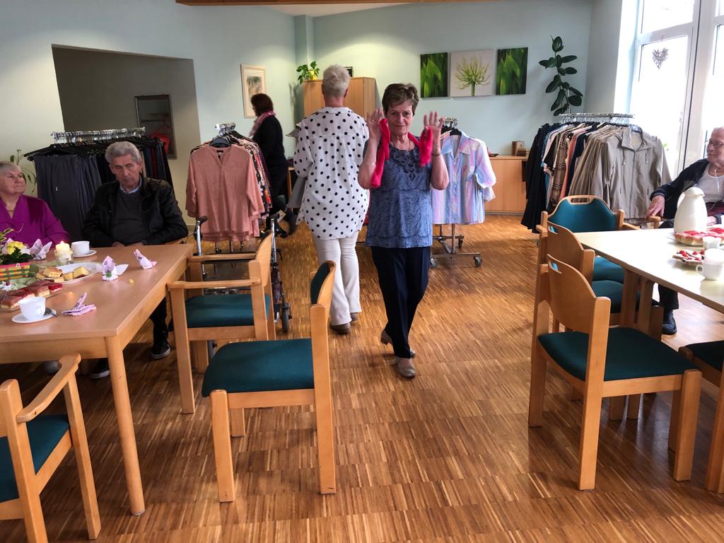 Ein Raum in einem Gemeinschaftszentrum mit Personen und Kleidungsstücken.