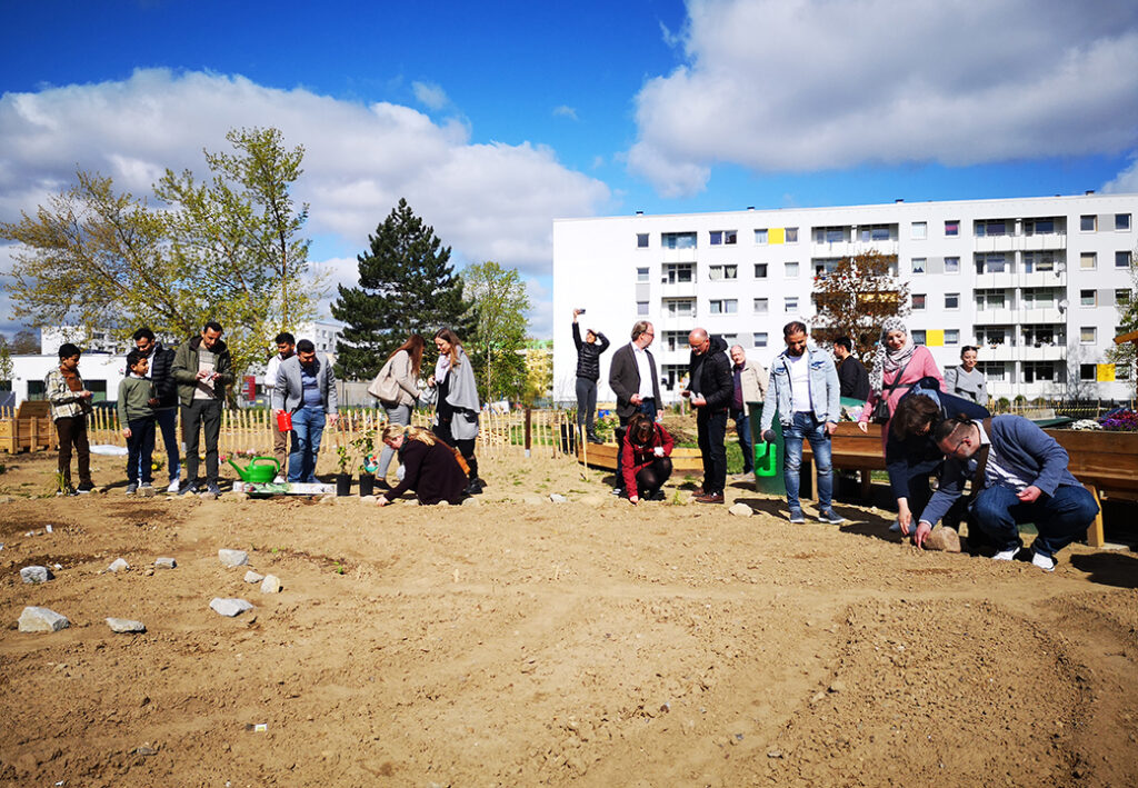 Gruppe von Menschen pflanzt in einem Gemeinschaftsgarten.
