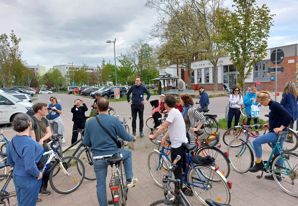 Gruppe von Menschen mit Fahrr&auml;dern versammelt auf einem Platz
