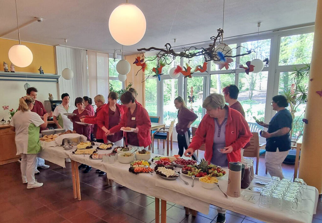 Menschen bedienen sich an einem B&uuml;fett.