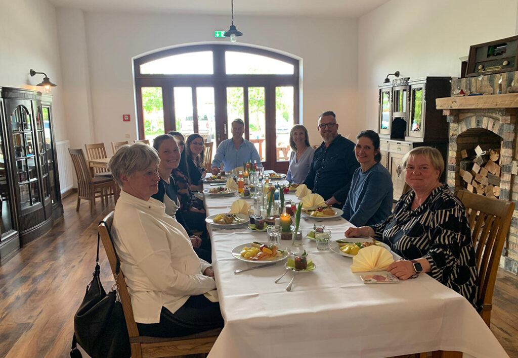 Menschen bei einem gemeinsamen Essen in einem Raum.