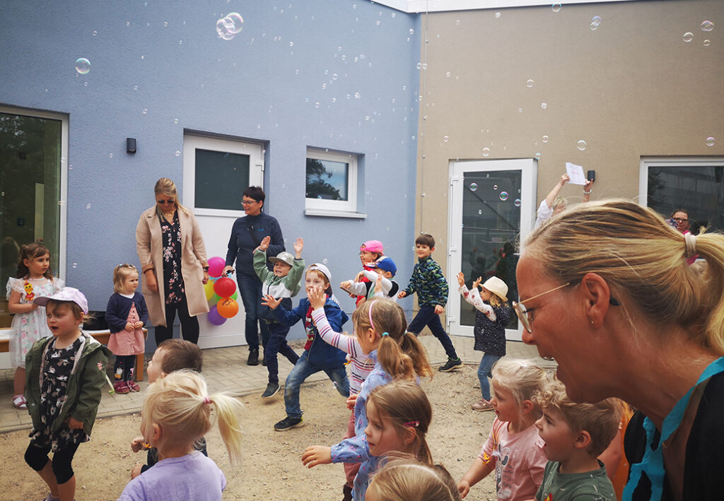 Gruppe von Kindern und Erwachsenen, die im Freien spielen