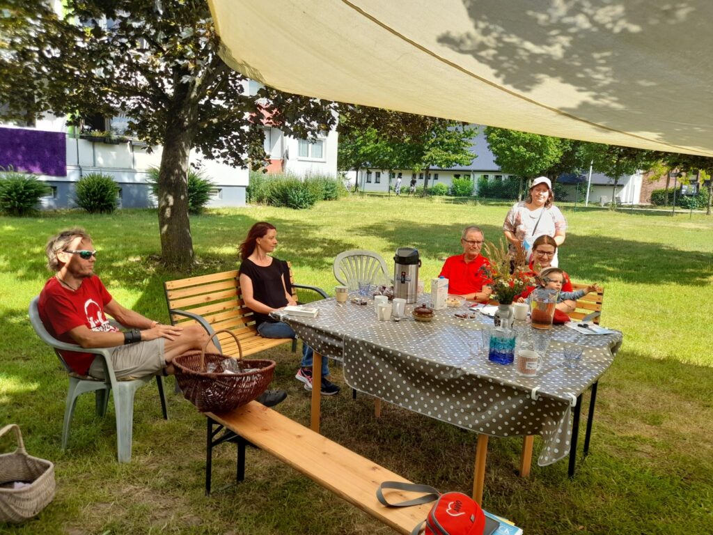 Eine Gruppe von Menschen sitzt an einem Tisch im Freien.