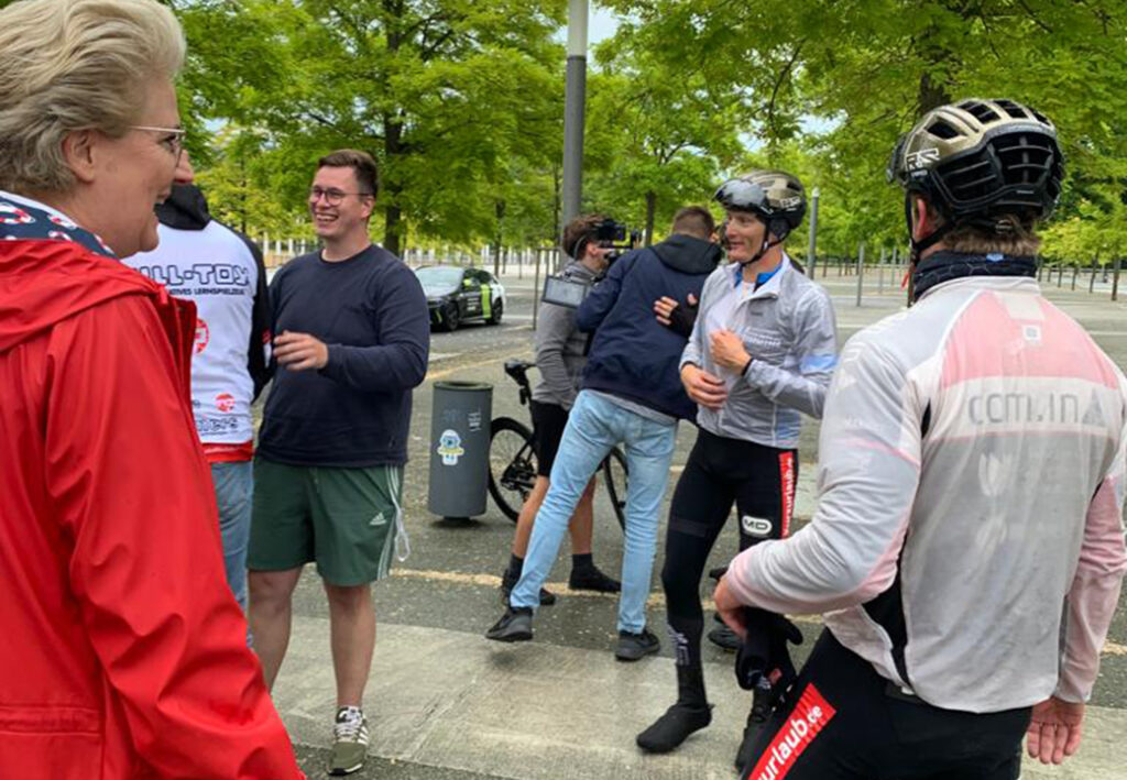 Menschen unterhalten sich w&auml;hrend einer Radsportveranstaltung im Freien.