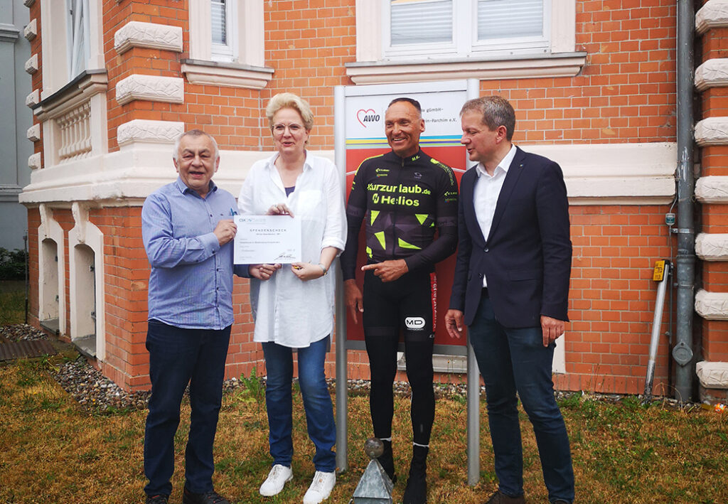 Vier Personen vor einem Ziegelgeb&auml;ude.