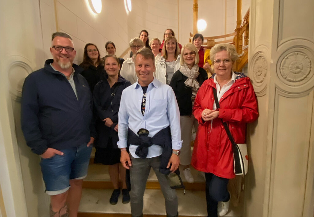 Gruppenfoto von Personen auf einer Treppe in einem Geb&auml;ude.