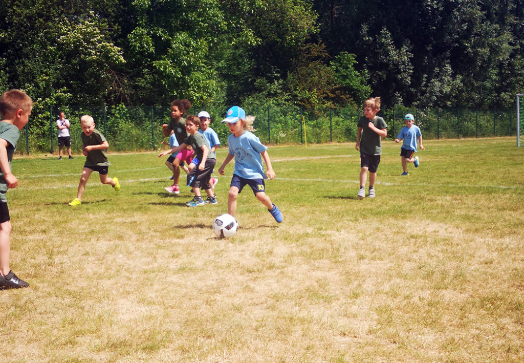 Kinder beim Fu&szlig;ballspielen auf einem Feld.
