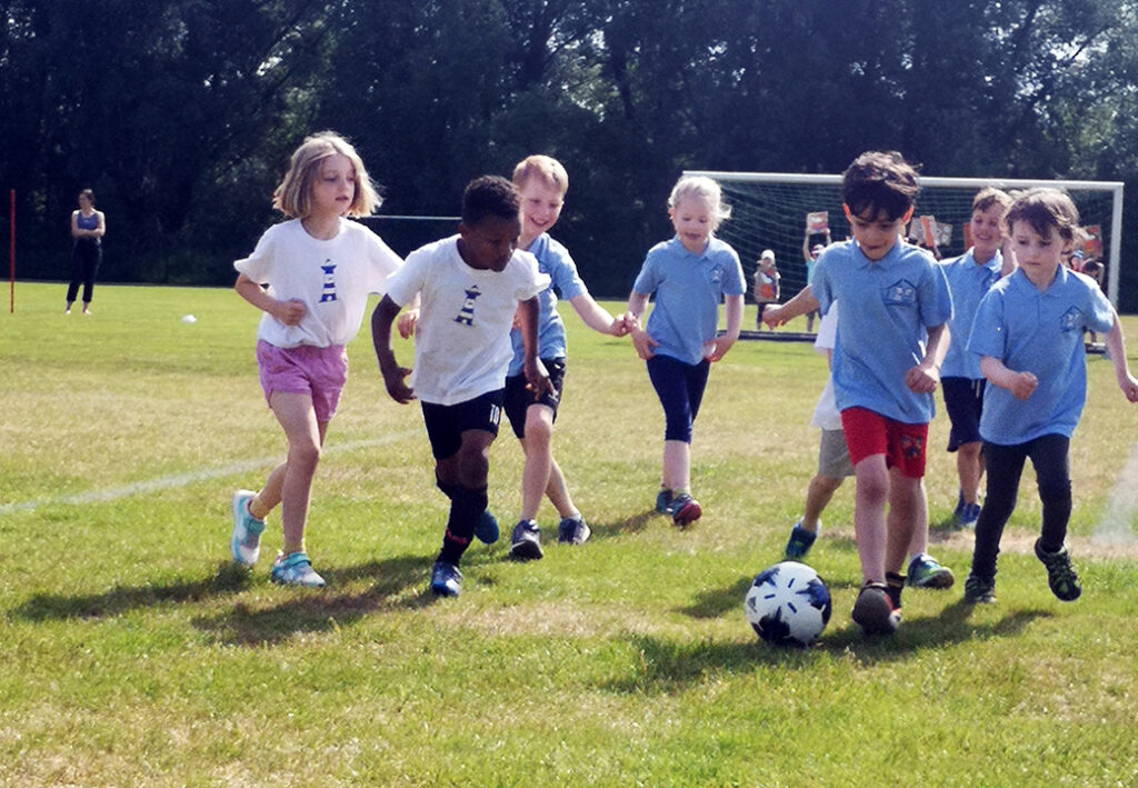 Gruppe von Kindern spielt Fu&szlig;ball im Freien
